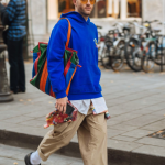 Streetwear colorful dengan perpaduan hoodie biru cerah dan celana krem, mencerminkan identitas unik melalui warna outfit