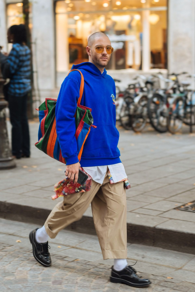 Streetwear colorful dengan perpaduan hoodie biru cerah dan celana krem, mencerminkan identitas unik melalui warna outfit